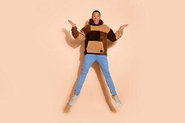Photo of cheerful positive man wear trendy clothes rejoice offer discount isolated on beige color background