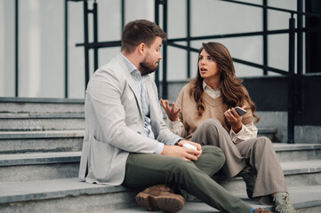 Business people having heated discussion on stairs outside office building
