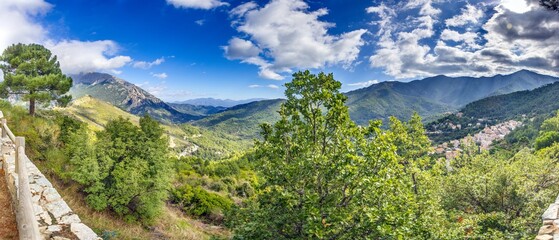 Aerial view of the picturesque mountain village Vivario on Corsica surrounded by lush green forested hills