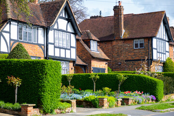 Walking on streets of North London, red brick houses and flowering gardens in spring, city life, wealthy neighbourhoods in London, UK