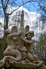 Obraz premium Neoclassical stone fountain with children and swan sculpture