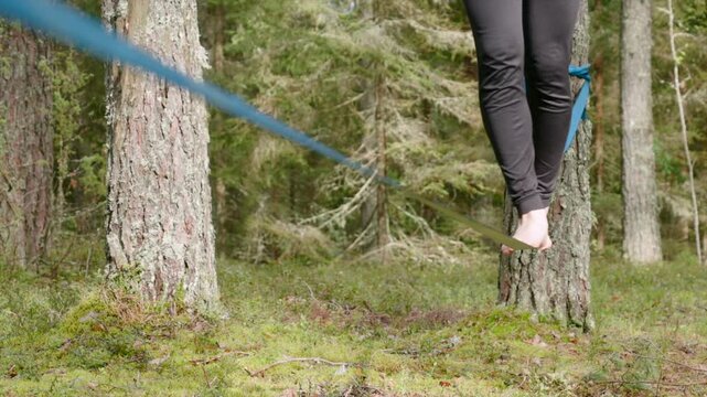 Close-up of person balancing on a slackline in a forest