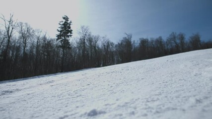 4K slow motion video of a male skier on a ski slope in cold winter making a close up turn down a resort run off a mountain, Vermont, USA. Excitement and thrill of an extreme sport.