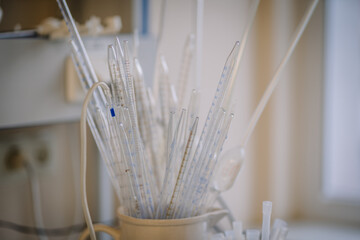 Close-up of laboratory glass pipettes in a container, used for precise measurement and transfer of...