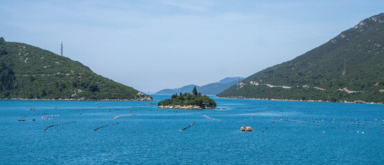 Seascape with oyster farm in the Adriatic Sea bay among the mountains.