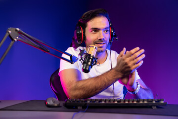 Smart gaming streamer talking with team member players using headset and mic for communicate with others on streaming live on social media application at digital neon lighting studio room. Surmise.