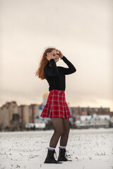 Obraz premium Portrait of a young beautiful red-haired girl on a winter snowy field.