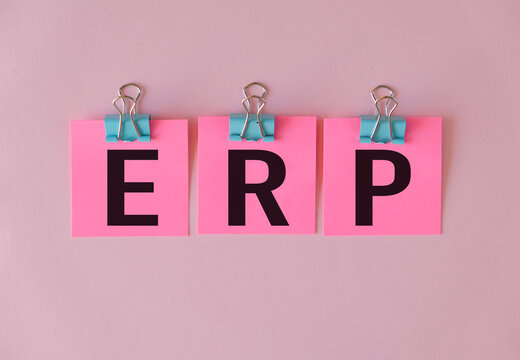 ERP text on a yellow sticker on pink background. Enterprise Resource Planning Concept. - Powered by Adobe
