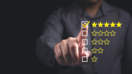 Businessman is pointing at a star rating review system with five stars checkmark in concept of customer satisfaction feedback survey.