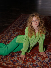 Beautiful girl with curly hair and makeup, posing emotionally in 90s-style clothes