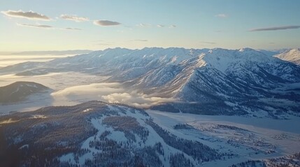 Obraz premium Snow-capped peaks rise majestically against a clear blue sky, while a subtle mist dances over a frozen lake at dawn, creating a serene winter landscape of breathtaking beauty