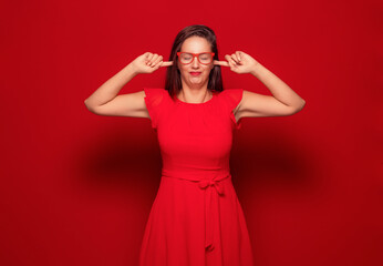 Noise - loud. Closeup portrait of a young angry unhappy stressed woman covering his ears closing...