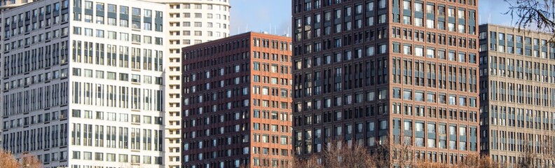 Large beautiful modern buildings are designed with lots of windows to showcase urban architectural design and public life.
