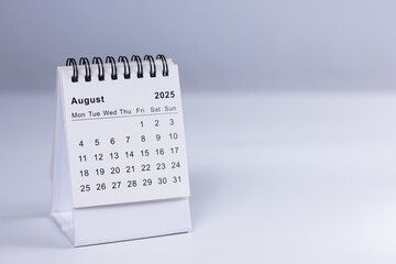 August 2025 calendar - month page on white desk