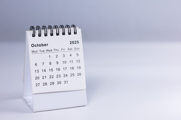 October 2025 calendar - month page on white desk