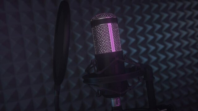 Recording studio with condenser microphone, pop filter and anti-vibration mount. Dark recording studio with purple neon light