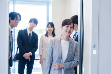 オフィスでエレベーターに乗るビジネスパーソン © maroke