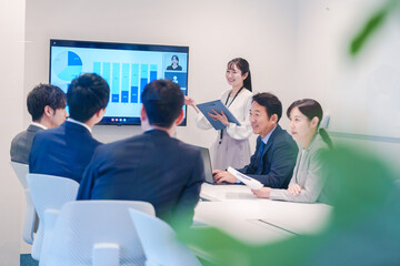 会議室でプレゼンをする若い女性