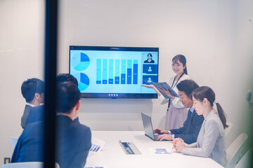 会議室でプレゼンをする若い女性