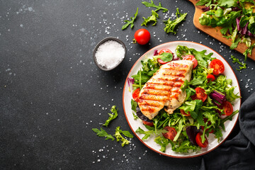 Dash diet food, healthy nutrition. Chicken steak with fresh salad on black background. Top view...