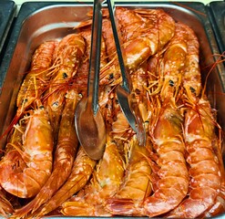 Shrimps useful for gourmets who love seafood are cooked and laid out on baking sheet