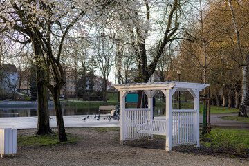 White swing in the city's spring park next to the lake.