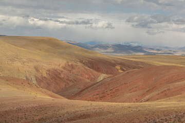 Fototapeta premium Wide mountain gorge Golden autumn landscape with colorful hills. Slopes with a red tint like on another planet similar to the Martian landscape.