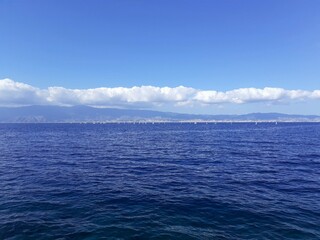 Lo Stretto di Messina visto da Reggio Calabria. Piccola regata velica in corso.