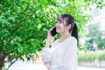 Fototapeta premium 外で通話をする若い女性