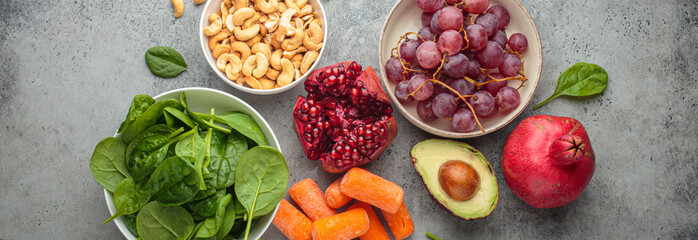 Assortment of healthy potassium rich foods including cashews, grapes, avocado, pomegranate, baby...