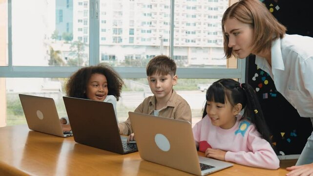 Smart teacher teaching and looking student using laptop at classroom. Professional instructor explained about programing engineering code or prompt while studying and learning program. Erudition.