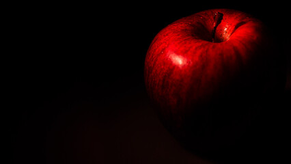 Zbliżenie na czerwona jabłko na czarnym tle. © Tomasz Jaskulski