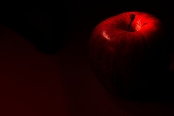 Zbliżenie na czerwone jabłko na czerwono - czarnym tle. © Tomasz Jaskulski