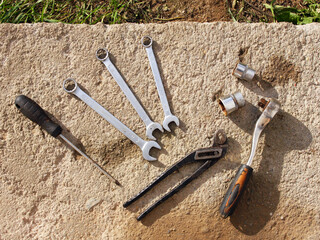 A set of old tools: wrenches, ratchet, screwdrivers, pliers, cap wrenches on a concrete surface background. Automotive repair, mechanics, car restoration, work and industry