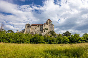 Fototapeta premium Ancient castles architecture in Europe. Austria medieval citadel made of bricks. Rocky walls of an old historical castle with towers and bridge on a sunny summer day, European landmark and history