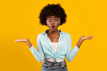 Shocked African American Young Woman Shrugging Shoulders Looking At Camera With Opened Mouth Or Posing Holding Two Invisible Objects On Hands Over Pink Background. Studio Shot