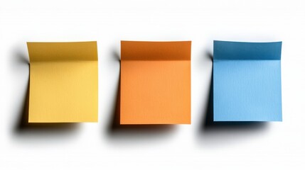 Fototapeta premium Three brightly colored sticky notes in yellow, orange, and blue stand out against a neutral background, capturing a sense of organization and creativity.