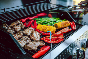 Cooking of meat and vegetables on a grill or on barbeque with temperature check.