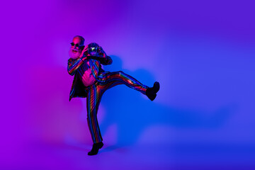 Obraz premium Full length photo of funky handsome guy wear glamour jacket dark spectacles enjoying doscotheque emtpy space isolated violet color background