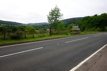 Fototapeta premium Road in scotland's great glenn way with drumnadrochit sign