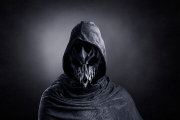 Creepy figure with animal skull at night over dark misty background