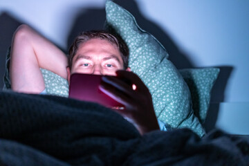 man with phone in bed in the dark, using phone before sleep, using phone before sleep. phone device...