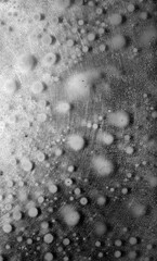 Black and white surface with soap drops in the water.