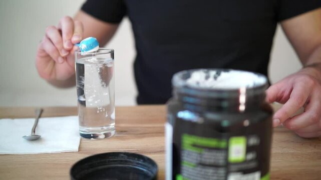 Young man prepares creatine in a glass of water