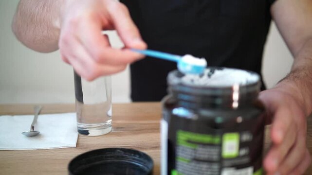 Young man prepares creatine in a glass of water