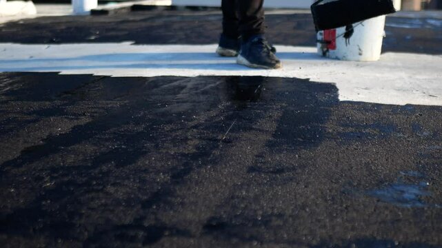Flat roof waterproofing preparation using mastic primer close up by professionals