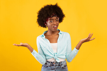 Discontented Black Young Woman Shrugging Shoulders Gesturing With Hands And Looking At Camera Standing Over Pink Background. Studio Shot. Huh, What's The Problem, Negative Female Emotions Concept