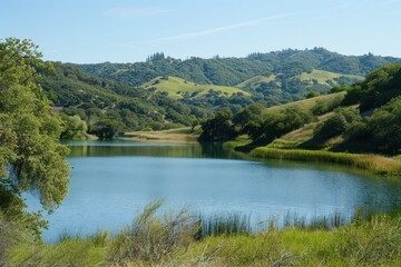 Obraz premium Scenic landscape with serene lake reflecting mountains and clouds in a tranquil setting during daytime