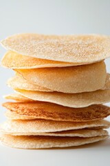 A stack of golden-brown, thin, crispy pancakes piled on each other, showcasing their texture and lightness, This image is perfect for food blogs, menus, or articles about breakfast options,