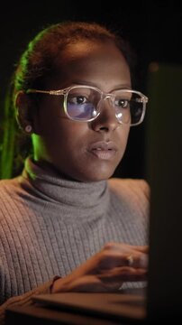 Vertical. Beautiful african woman IT engineer inspecting a secure server cabinet using modern technology laptop coworking with female technician in data center. High quality 4k footage